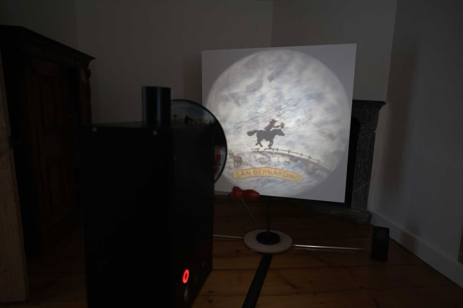 Traveling Der Ratsbote reitet mit seinem Dokument durch das Gewitter am San Bernardino. Die Leinwand ist eine gestrichene Sperrholzplatte die frei im Raum steht und so ein freier Verweis auf das Medium der frühen Projektionstechnik ist. 