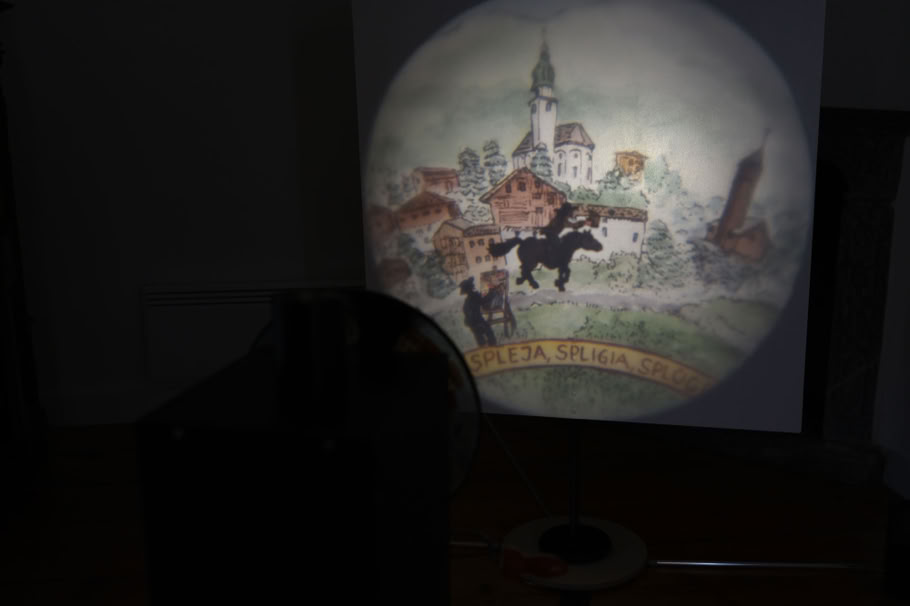 Der Ratsbote reitet mit seinem Dokument durch Splügen. Beim Drehen an der Kurbel zieht der Hintergrund vorbei. Das System des Travelings ermöglicht verschiedene Erzählungen in der Art eines kleinen Roadmovies.